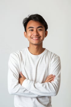 Portrait of asian young man with arms crossed standing on white background photo