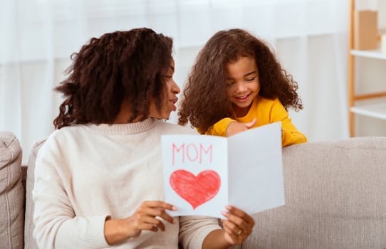 Happy Mother's Day. Little African Girl Congratulating Mom Giving Self-Made Postcard At Home. photo