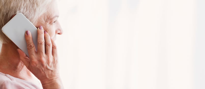 Close up of mature attractive retired woman talking by phone with family, looking aside, panorama with copy space photo