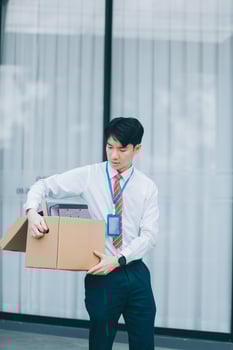 Sadness depressed Businessman with box cardboard packing personal items after losing jobs. Failure businessman sitting at stair front of building. Your fired Unemployed Jobless People Crisis photo
