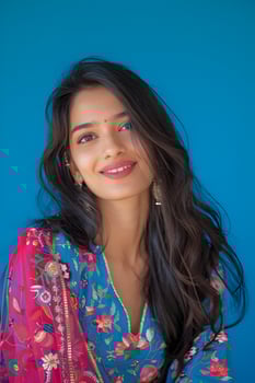 Smiling Young Indian Woman Wearing Colorful Kurta Top Against Blue Background photo