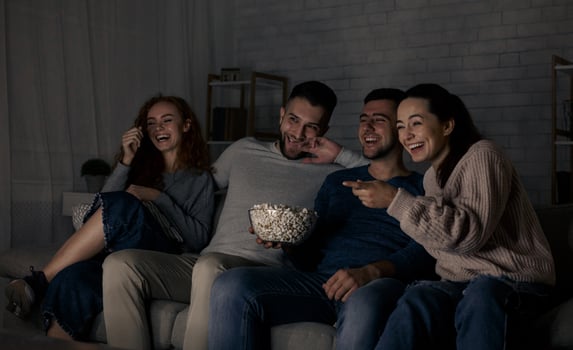 Happy friends watching comedy film and laughing, relaxing at home together photo