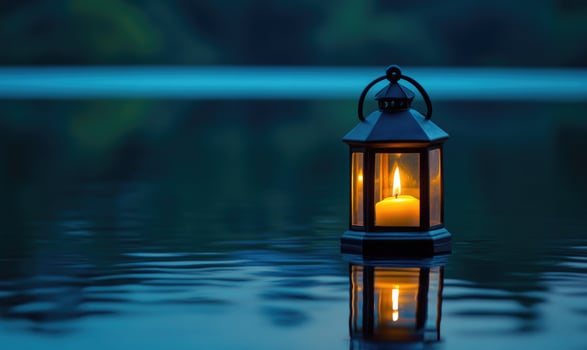 Lantern with a flickering light floating on still water photo