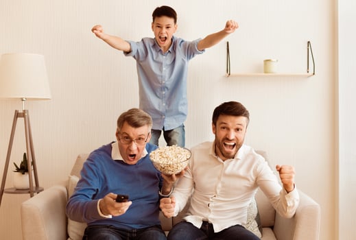 Goal. Boy With Father And Grandpa Watching Soccer Match On TV And Shouting Celebrating Victory Indoor. Selective Focus photo