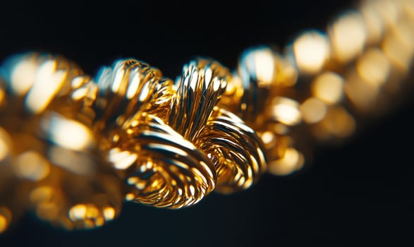 A gold chain with knots is shown in a close up photo