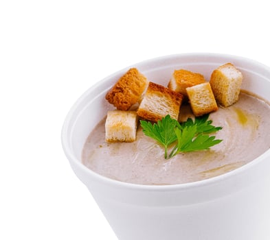 Creamy mushroom soup being served with croutons and parsley photo