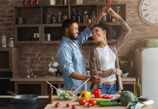 Happy romantic couple dancing in kitchen while cooking together photo