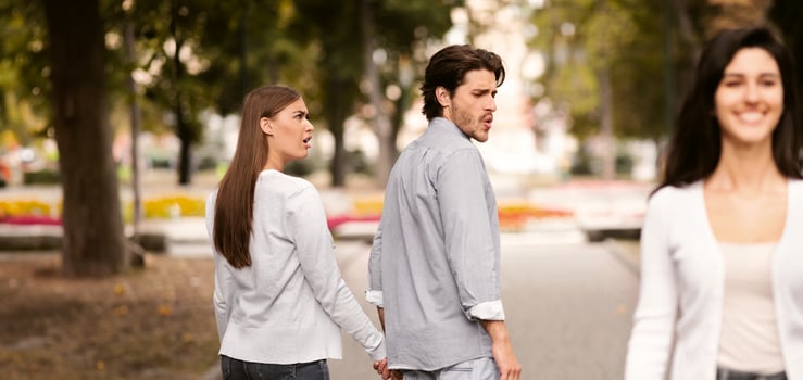 Boyfriend Looking At Other Girl Walking With His Irritated Girlfriend Outdoor In Park. Relationship Problems. Selective Focus photo