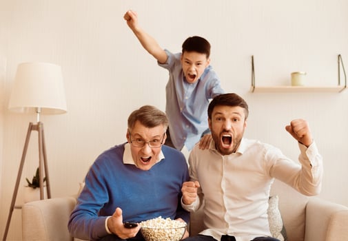 Football Fans. Grandfather, Father And Son Watching Match On TV And Shouting Celebrating Win At Home. Selective Focus photo
