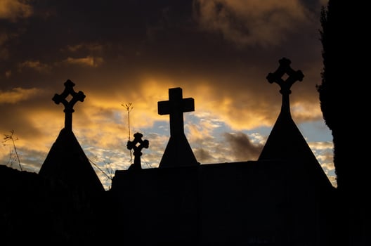 Silhouettes of crosses in front of a sunset photo
