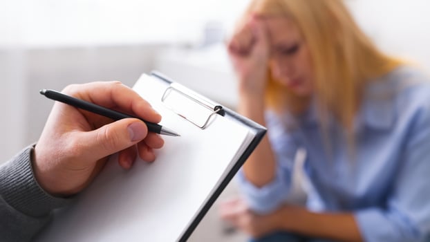 Psychological diagnosis. Professional skillful psychologist taking notes, listening to her patient, empty space photo