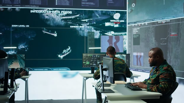 Military crew in a high tech operations command post managing information from radar cctv systems, real time data to support defense missions. Army protocols for national security. Camera B. photo