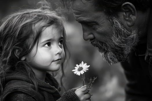 Little girl with flower and father sharing moment of joy in black and white photo