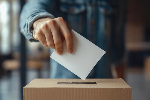 Woman putting ballot paper in vote ballot box photo