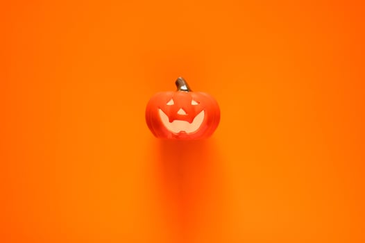 Halloween background with Jack o lantern that have light inside on orange background. Minimal concept. photo