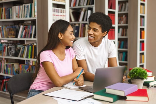Lovely couple of black students working with science project in library, free space photo
