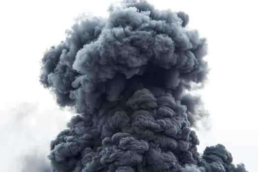 Thick, swirling black smoke ascends against a stark white background, exhibiting intricate patterns and varying opacities, showcasing its fluid nature and dramatic presence photo