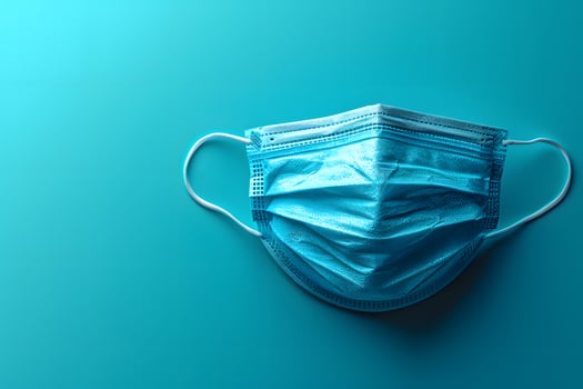 Single Blue Medical Face Mask on Aqua Background for Healthcare and Hygiene Concept photo