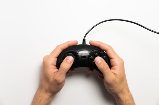 Male hands holding retro gamepad on white background. Flat top photo