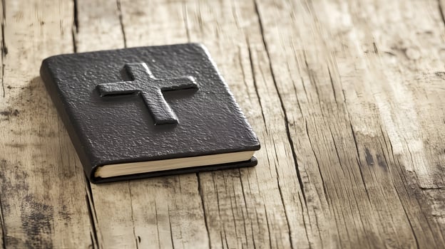 A black book with a cross rests on a rustic wooden background with space, inviting contemplation and reflection photo
