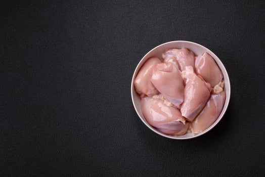 Fresh chicken fillet on a dark concrete table with spices and herbs photo