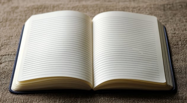 A blank notebook lies open on a blue surface, inviting creativity and ideas to flow freely photo