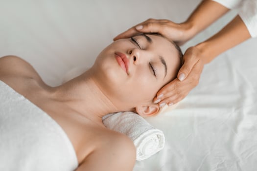 A young blonde woman enjoys a relaxing facial massage at a spa, embodying serenity and tranquility in a soothing environment photo