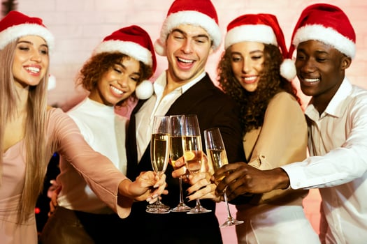 Christmas. Happy Young People Clinking Glasses Drinking Champagne Celebrating Xmas Standing Against Wall Indoor photo