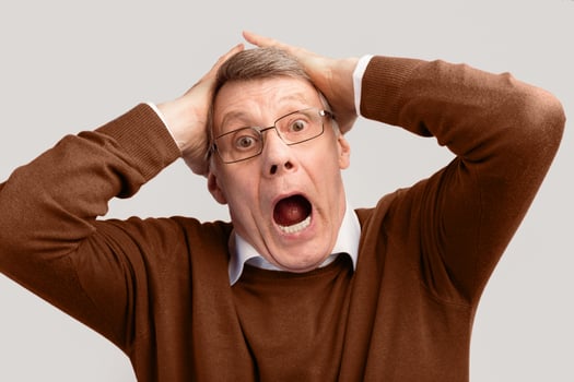 Shocked Elderly Man Shouting Clutching Head Looking At Camera Standing Over Gray Background. Stress Concept. Studio Shot photo