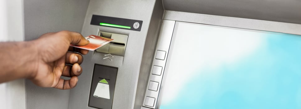 Close up of black man using ATM with gold credit card, panorama, copy space photo