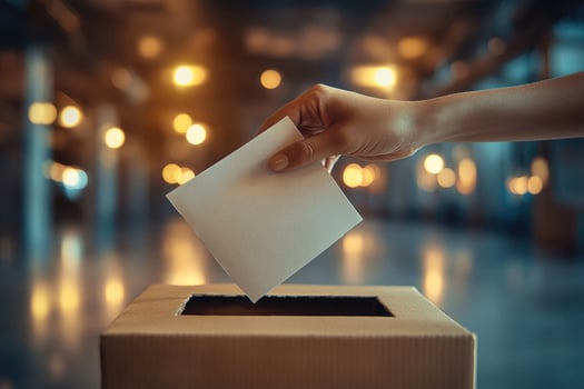 Woman is putting ballot paper in the box at polling place photo