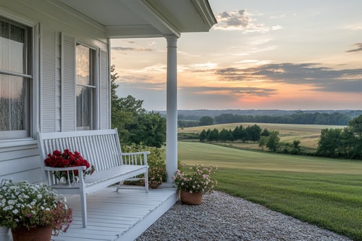 White bench sitting on front porch overlooking sunset on countryside farm photo