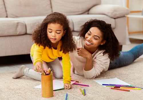 Cheerful Afro Mother And Daughter Drawing Spending Time Playing And Bonding Together On Floor At Home. Selective Focus photo
