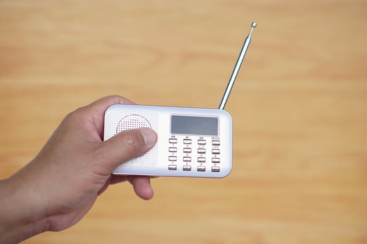 Hands hold portable mini radio. Concept, audio electronics for listening to music, songs or news from radio wave channel station. Analog amplifier for relaxation and lifestyle. photo