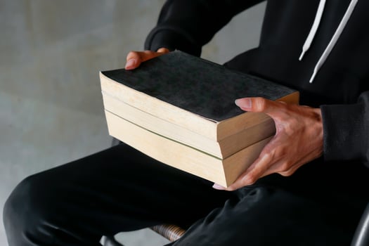 Male hand holding a stack of books. Education and knowledge concept. Portrait of young man book lover photo