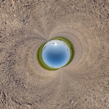 blue hole sphere or globe little planet inside sand or dry ground frame background with tractor tracks photo