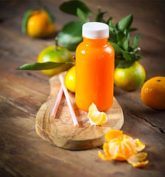 One bottle of fresh tangerine juice with ripe tangerines photo