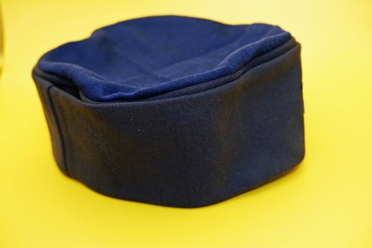 black peci isolated on yellow background. black cap used for prayer by male muslims. photo