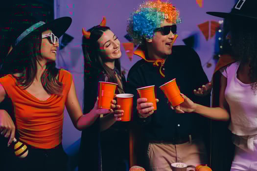 Joyful office Halloween party with coworkers in costumes, celebrating with drinks and laughter, fostering teamwork and festive spirit photo