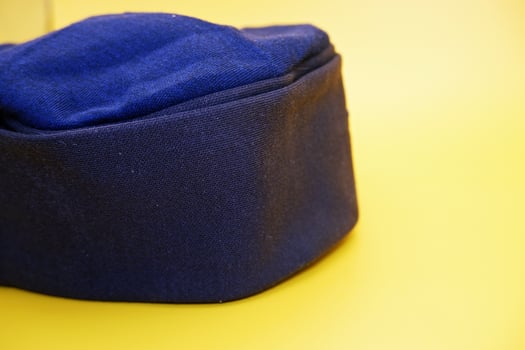 black peci isolated on yellow background. black cap used for prayer by male muslims. photo
