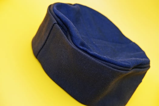 black peci isolated on yellow background. black cap used for prayer by male muslims. photo