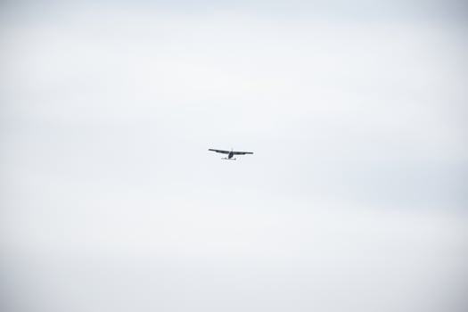 Single Aircraft Flying in Overcast Sky photo