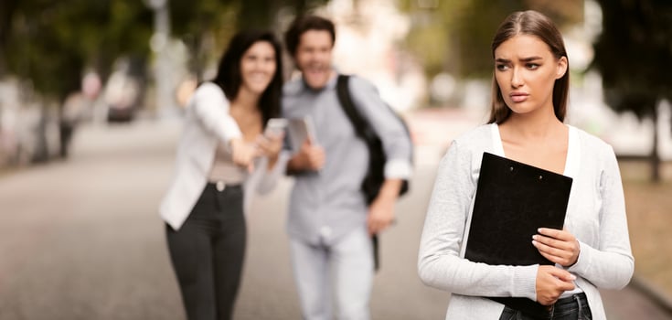 Bullying Concept. Unhappy Girl Being Bullied By Couple Of Students Walking Outdoor. Selective Focus. photo