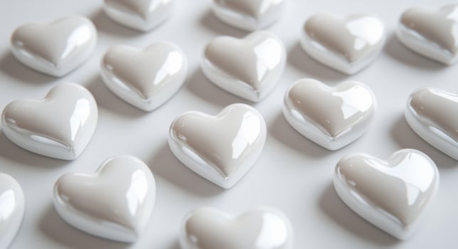 A collection of glossy white heart-shaped decorations scattered on a flat surface photo