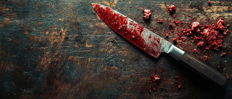 A knife with blood on it on a wooden table photo