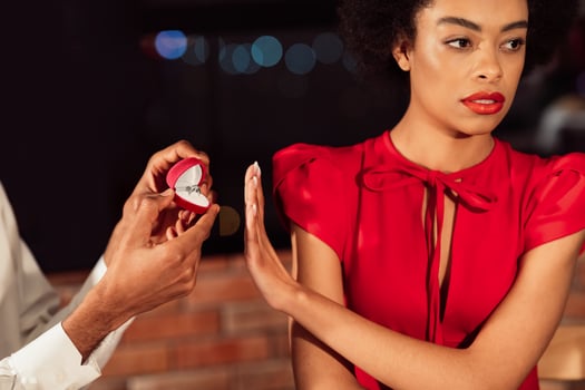Refusing Marriage Proposal. Afro Girl Gesturing Stop To Offered Engagement Ring Rejecting Her Boyfriend In Restaurant. Cropped photo