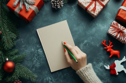 Holiday gift planning with a notebook, red presents, and festive decorations on a table photo