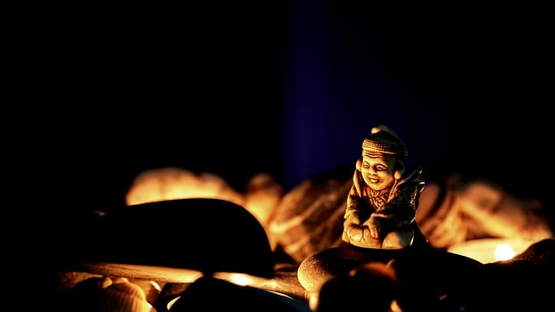 Figurine of the holy Buddha, mineral stones,light in night photo