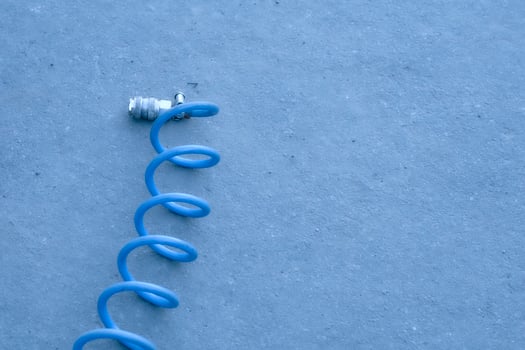 Coiled hose for inflating car wheels with air on asphalt photo