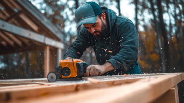 Man in a Blue Cap Using a Power Sander on Wood photo
